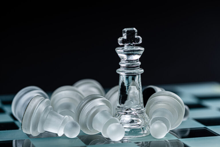 glass chess board game in black background ,selective focus on K